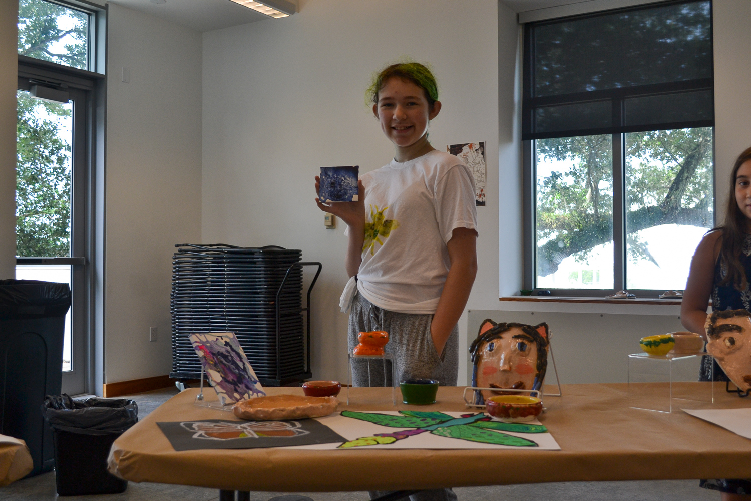 A Mud Daubers Summer Camper shows off their artwork