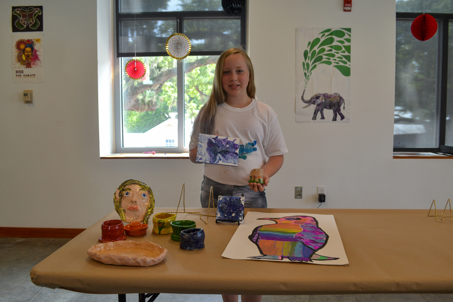 A Mud Daubers Summer Camper shows off their artwork