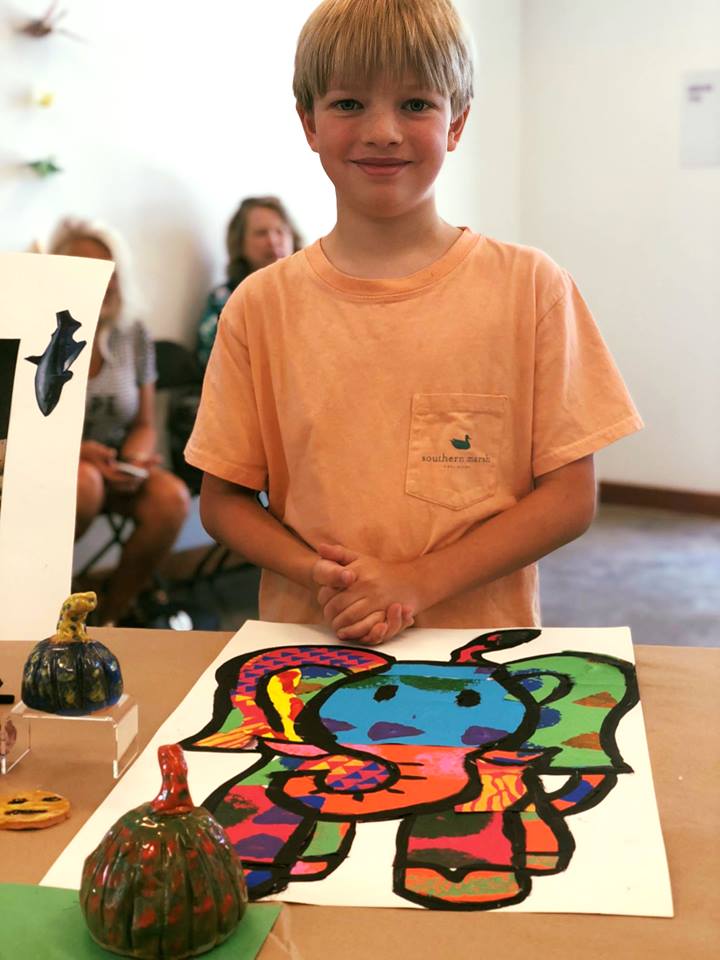 A Mud Daubers Summer Camper shows off their artwork